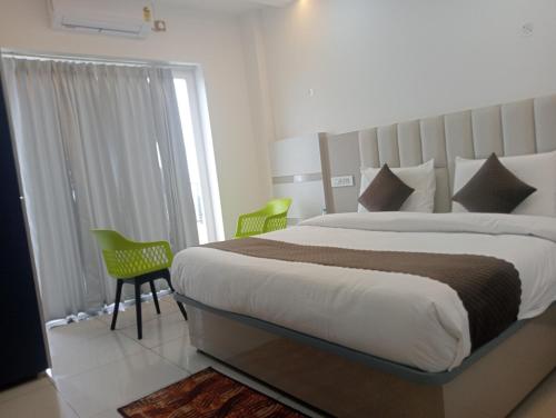 a bedroom with a large bed and two chairs at Avantika Hotel in Bharwain
