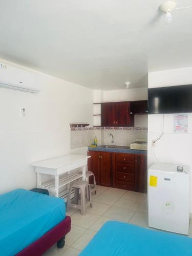 a kitchen with a white table and a white refrigerator at Casa de Huéspedes Playas Arena in Playas