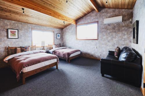 a bedroom with two beds and a couch in it at Monterey House by SANA in Tateyama