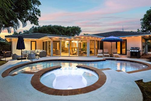 a swimming pool in the backyard of a house at The Coastal Duo Escape in West Palm Beach