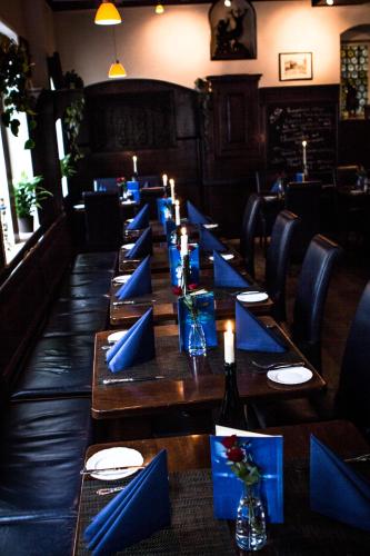 a long table in a restaurant with blue napkins and candles at Hotel Blaue Ecke in Adenau