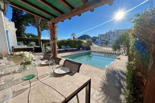 - une table avec des verres à vin et une piscine dans l'établissement Charming house with swimming pool and mooring, à Grimaud