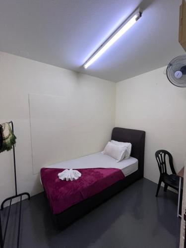 Piccola camera con letto e coperta viola. di 4 BR House at Seksyen 4 BB Bangi a Bandar Baru Bangi