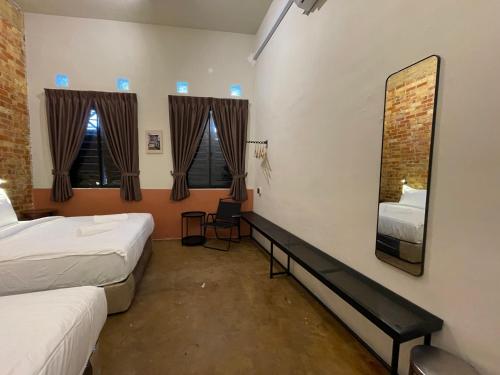 a hotel room with two beds and a mirror at Miner's House Ipoh in Ipoh