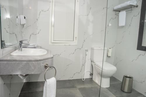 a white bathroom with a sink and a toilet at Beverly Beach Hotel in Jounieh
