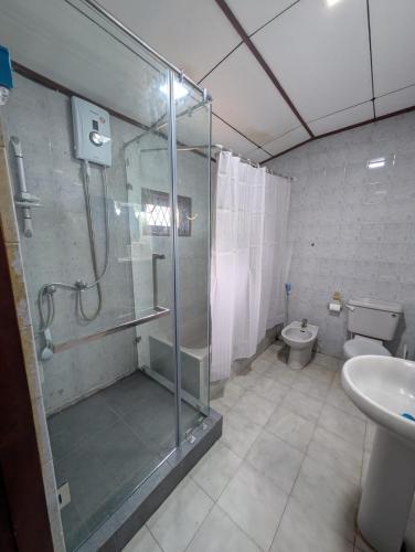 a bathroom with a shower and a toilet and a sink at Dona's Villa, Coastal Tropical House in Kepungoda