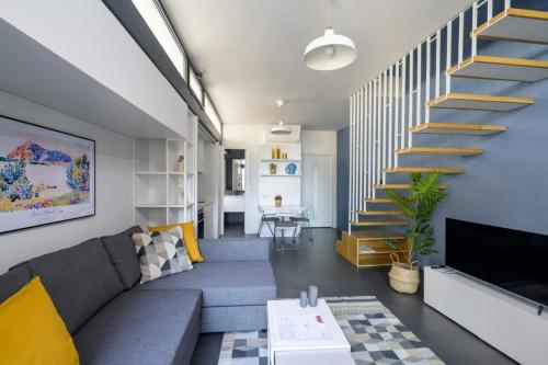 a living room with a couch and a staircase at Bright Modern Design New Duplex Loft Patio! #145 in Istanbul