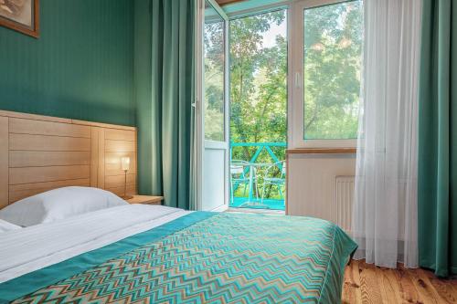 a bedroom with a bed and a large window at Seasons SPA Boutique Hotel in Kozin
