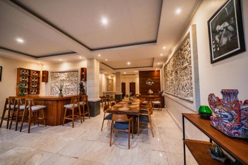 a dining room with tables and chairs and a bar at Oka Suite Sebatu Ubud in Tampaksiring