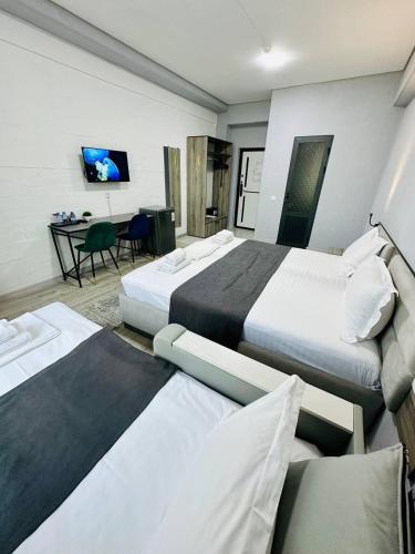 a hotel room with three beds and a table at Beshchinor Hotel in Yakkasaray