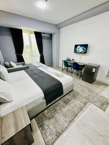 a large bedroom with a large bed and a desk at Beshchinor Hotel in Yakkasaray