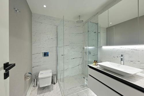 une salle de bain avec un lavabo et une douche en verre dans l'établissement Gorgeous Modern 1bd Terracepoolviews! #183, à Istanbul