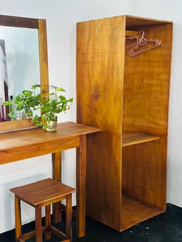 a wooden desk with a mirror and a stool at Nature Garden in Pottuvil