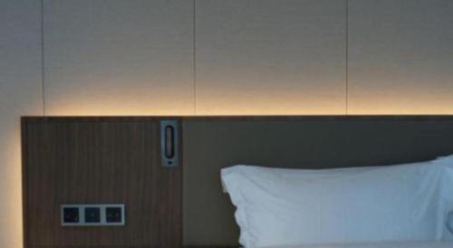a headboard of a bed with a white pillow at Empark Grand Hotel Fuzhou in Fuzhou