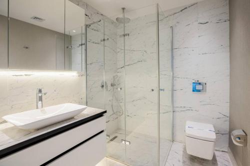 a bathroom with a sink and a glass shower at Gorgeous Modern 1bd Condo Views W Poolgym! #255 in Istanbul