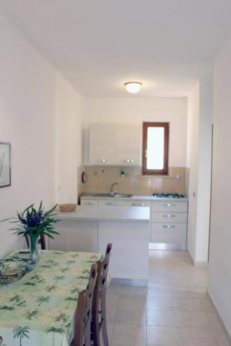 a kitchen with a table and a kitchen with white cabinets at Casa Roberta in Capoliveri