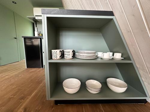 a shelf with plates and bowls in a room at Greenkova in Kamenitsa