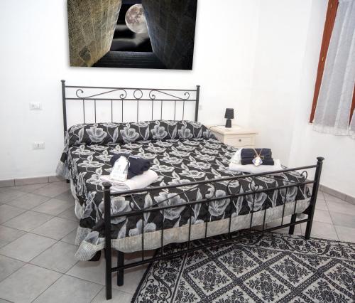 a bedroom with a black bed with pillows on it at B&B San Leonardo Dualchi in Dualchi