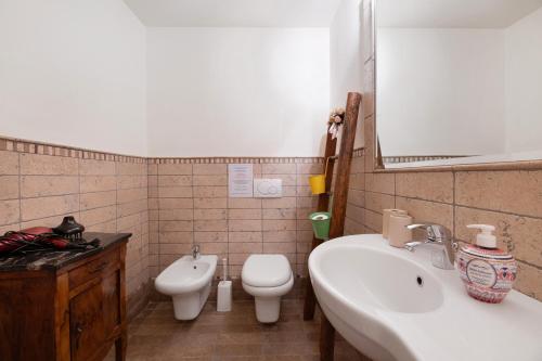 a bathroom with a sink and a toilet and a mirror at Villa Alessandra in Pellio Inferiore