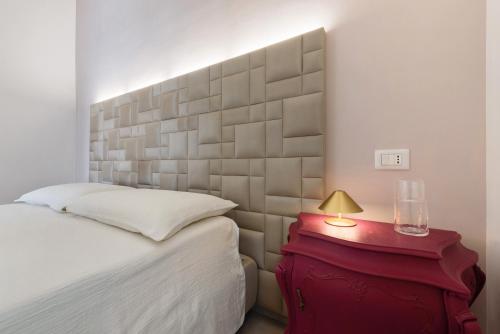 a bedroom with a bed and a red table with a lamp at Casa Teresa Suite in Como in Como
