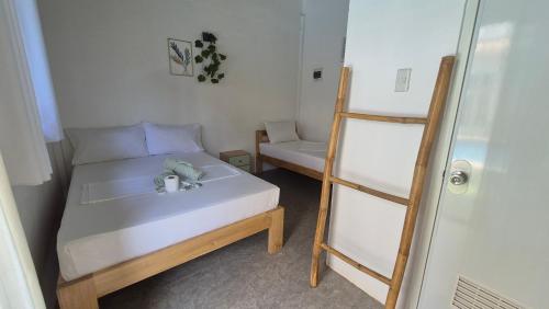 a small bedroom with a bed and a ladder at Camotes Hostel Resort in Camotes Islands