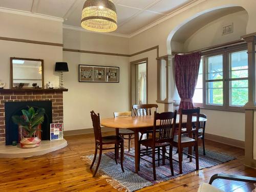 une salle à manger avec une table et des chaises et une cheminée dans l'établissement Hanami Place - Kandos - 4 bedroom house 1-8 people, à Kandos