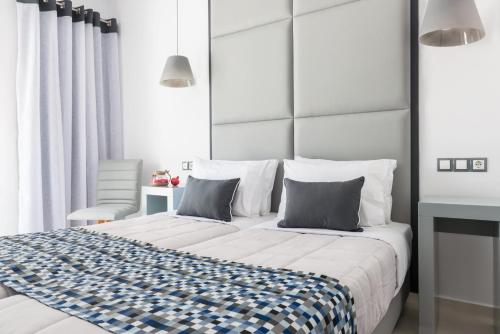a bedroom with a large bed with blue and white sheets at Sweet Pop in Fira