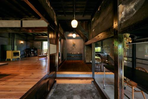 an empty room with wood floors and a hallway at 一棟貸し古民家宿「nagare」 in Iijima