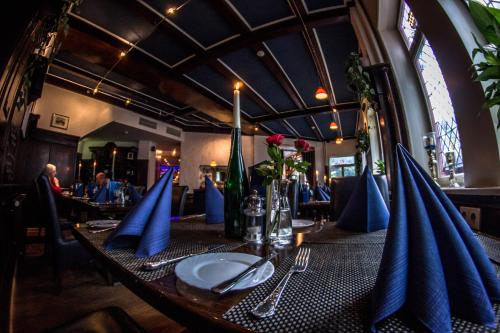 a table in a restaurant with blue napkins on it at Hotel Blaue Ecke in Adenau