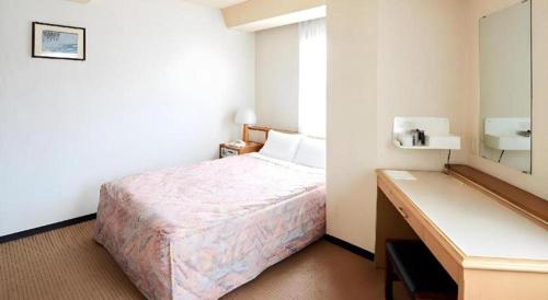 a hotel room with a bed and a mirror at Marroad Inn Tokyo in Chofu