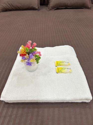 a table with a white towel with a vase of flowers at Shyam Residency - 50 mtr from Ram Mandir in Ayodhya