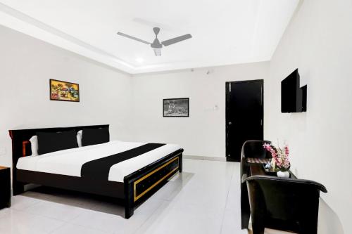 a bedroom with a black and white bed and a chair at Super Townhouse Daba Garden Road in Visakhapatnam