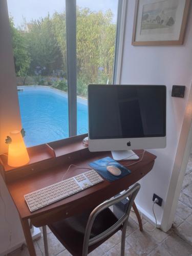 un bureau avec un moniteur d'ordinateur, un clavier et une souris dans l'établissement Welcome les Portes, aux Portes