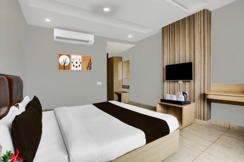 a hotel room with a bed and a tv at Super Hotel O Haldwani Near Bus Stand in Haldwāni