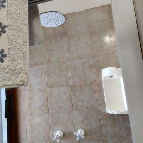 a bathroom with a shower with a tile floor and a toilet at GallyBi in Gallipoli