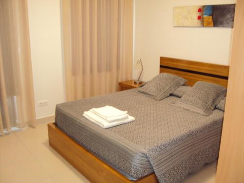 a bedroom with a bed with two towels on it at Casa do Mosteiro de Refoios do Lima in Ponte de Lima