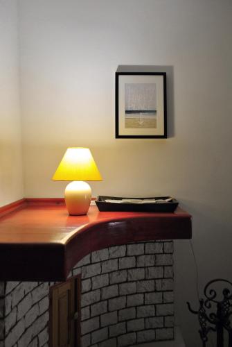 a table with a lamp on top of a brick fireplace at Totális Harmónia Villa in Miskolctapolca