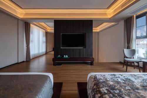 a hotel room with two beds and a flat screen tv at 诺亚度假酒店 in Luang Prabang