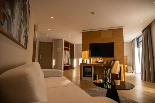 a living room with a couch and a tv at White Hill Hotel, SPA & Conferences in Durrës