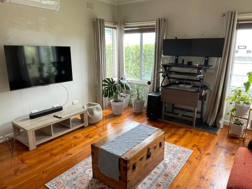a living room with a large flat screen tv on a wall at Cute cottage in a Supreme Location in Geelong