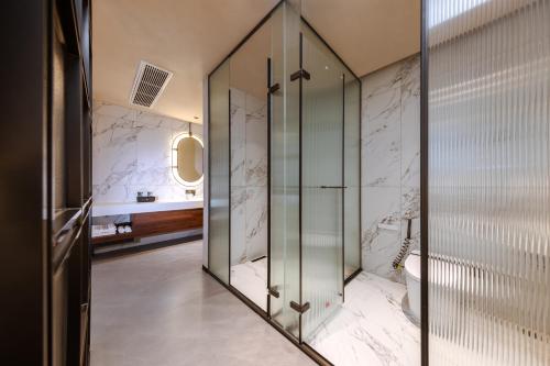 a glass shower in a bathroom with marble walls at 诺亚度假酒店 in Luang Prabang