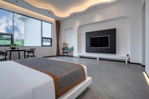 a bedroom with a bed and a flat screen tv at 诺亚度假酒店 in Luang Prabang