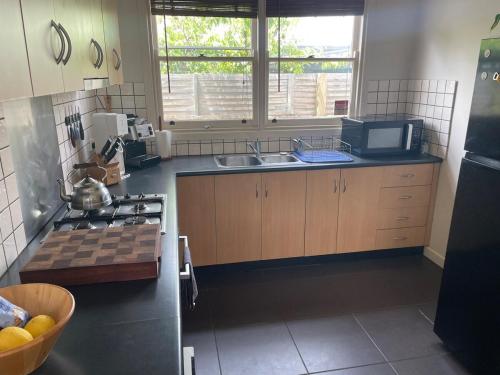 a kitchen with a sink and a stove top oven at Cute cottage in a Supreme Location in Geelong