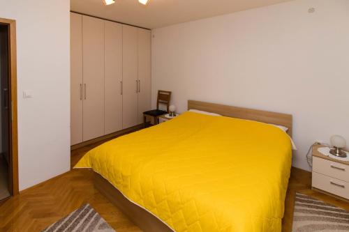 a bedroom with a large yellow bed in it at Apartment Peran in Šibenik