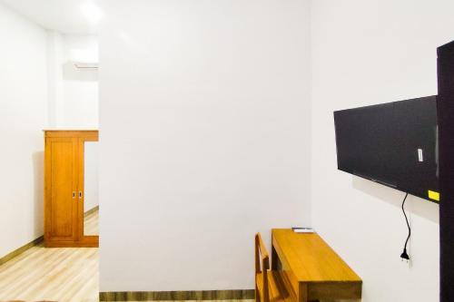 a living room with a television on a wall at Urbanview Hotel Syariah at Glory Guest House Kota Baru in Sultan Thaha Airport