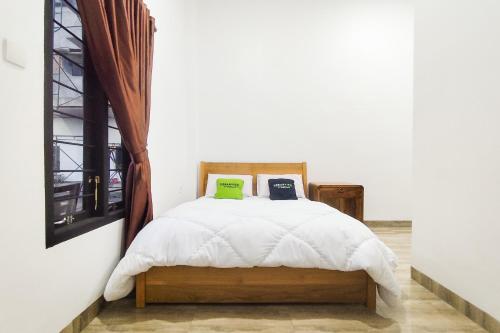 a bedroom with a bed with two laptops on it at Urbanview Hotel Syariah at Glory Guest House Kota Baru in Sultan Thaha Airport