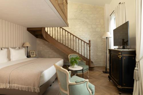 a bedroom with a large bed and a staircase at Hotel Du Quai Voltaire in Paris
