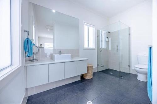 a white bathroom with a sink and a toilet at Ocean Front retreat Fleurieu Coast Wirrina Cove in Wirrina Cove