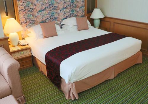 a bedroom with a large bed in a hotel room at Grand Palace Hotel in Miri
