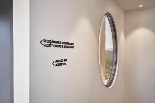 a mirror on a wall with a sign on it at The Vinea Collection Hotel by Piamonte Hotels in Monção